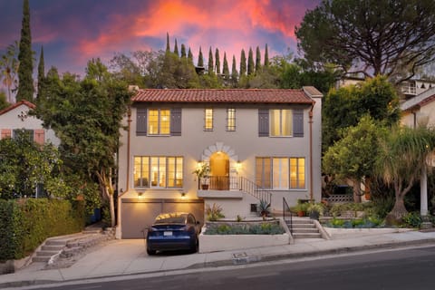 Elegant exterior at dusk showcasing the home's warm glow and charming curb appeal.