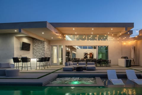 The entire outdoor space glows at night. Enjoy the heated spa, full outdoor bar, and string lights over the patio.