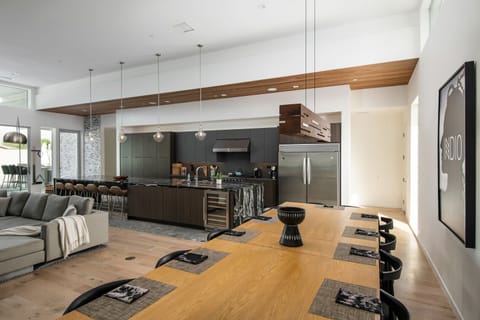 The expansive chef's kitchen and dining area, featuring a massive marble island, professional appliances, and plenty of seating for your entire group.