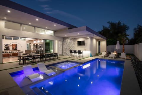 The ultimate evening paradise: The illuminated pool and hot tub are complemented by the covered outdoor bar and dining area.