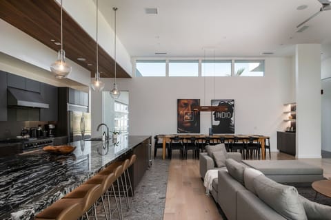 The stunning open-concept interior, showing the continuous flow between the modern kitchen island, living room, and dining space.
