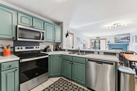 Your fully-equipped kitchen features sage green cabinets and stainless steel appliances, perfect for cooking memorable meals together.