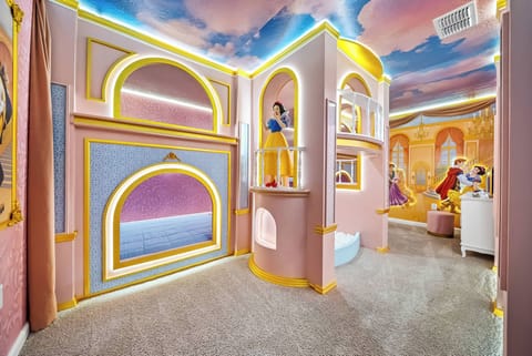 Step into a whimsical world where vibrant pinks and golden trims create a playful atmosphere. Featuring enchanting wall murals and uniquely designed nooks, this room invites imagination and fun for guests of all ages.