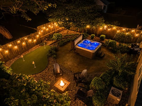 Private backyard oasis with hot tub, fire pit, and putting green