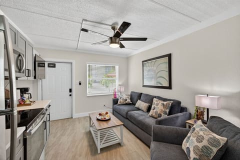 Bright living room w/ comfy seating, ceiling fan & TV—perfect for relaxing after a day out