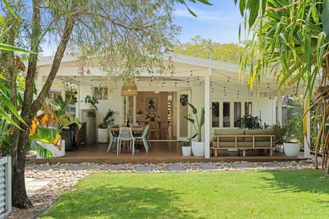 Step into a breezy tropical sanctuary where the wide timber deck invites relaxed gatherings amid lush greenery and soft, sunlit ambience.
