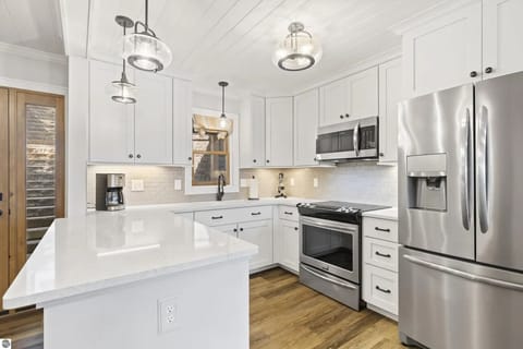 KITCHEN (MAIN FLOOR): The home has a beautiful modern kitchen with all appliances (including a dishwasher) and a good supply of cooking and dining utensils