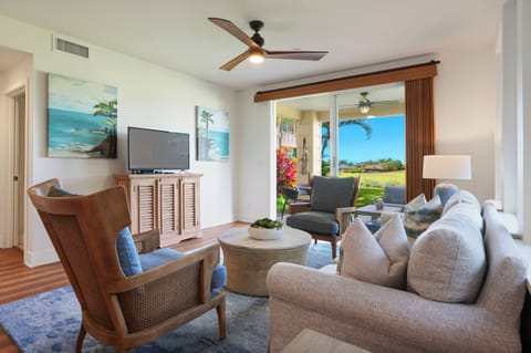 Inviting living space with comfortable seating, a flatscreen TV, and views through sliding glass doors.
