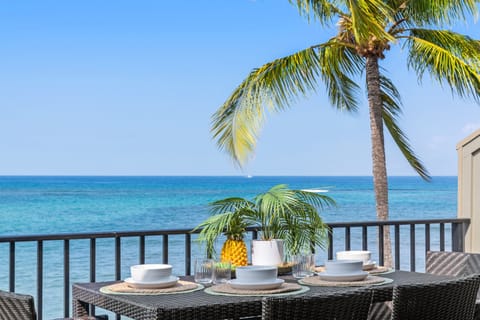Dine al fresco on a private oceanfront balcony with stunning views of turquoise waters and swaying palms—your perfect island escape