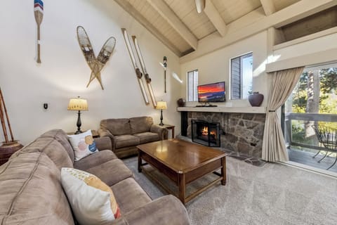 Cozy up by the stone fireplace with vintage ski decor creating the perfect mountain retreat atmosphere for your getaway.