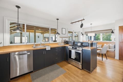 Modern kitchen featuring a gas stove, breakfast nook and doors to the indoor pool area