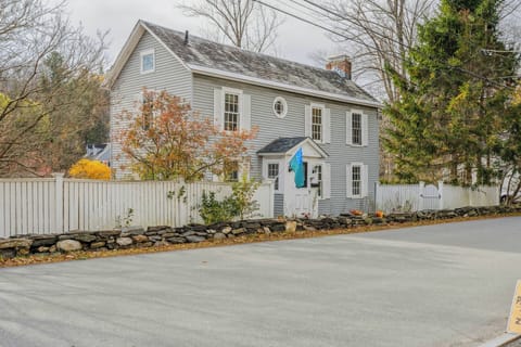Classic New England colonial with white picket fence and stone wall at 42 River Street