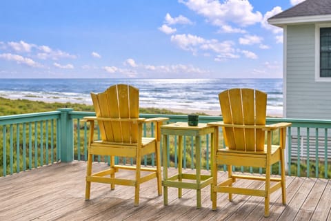 Beachfront deck with Adirondack chairs overlooking the Gulf of Mexico, perfect for relaxing and enjoying ocean views in Bolivar Peninsula vacation rental.