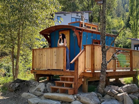 Cozy Gypsy Wagon retreat with a sunny wooden deck and forest views