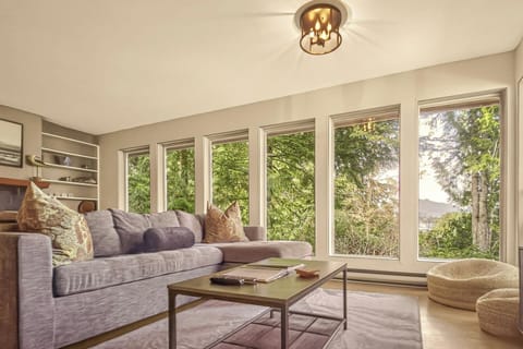 Sun-soaked living space with wall-to-wall windows and serene forest views—your front-row seat to the coast’s natural beauty.