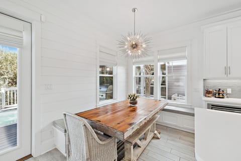 Dining area with ample seating in an open-concept layout, adjacent to the kitchen and living area, overlooking the pool.