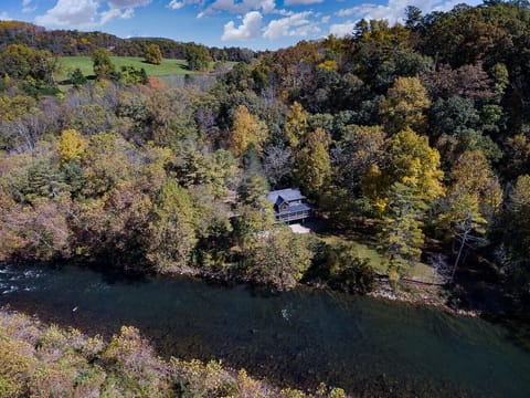 Stunning Aerial View of the Property Nestled Among Lush Green Trees with a Scenic River Beside It