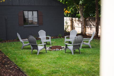 The backyard with picnic table, grill, and fire pit is ideal for gatherings and outdoor fun.