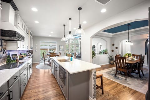 Open kitchen flows to formal dining, counter top seating, and breakfast table