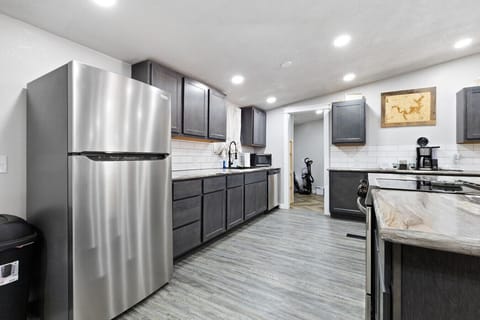 Modern Kitchen | Large Island with Bar Seating | Stainless Steel Appliances | Sleek Gray Cabinets & Subway Tile Backsplash
