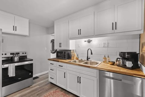 Clean, modern kitchen w/ white cabinetry, sleek appliances & plenty of prep space.