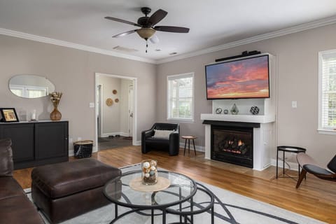 Large living room with multiple seating areas, a smart TV, an operating fireplace, and a game cabinet! The living room leads out to the screened-in porch.