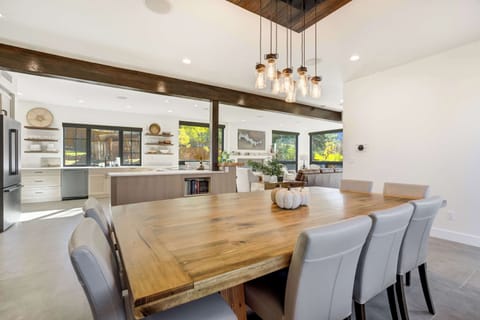 A spacious dining table sits beneath elegant lighting, creating the perfect setting for family meals or relaxed evenings surrounded by scenic Colorado beauty.