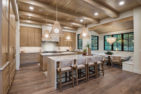 A huge chef's kitchen is well stocked with premium appliances and supplies, two kitchen islands, a built in dining area with beautiful alpine views.