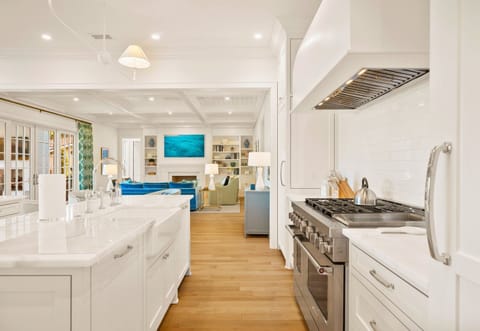The kitchen has white cabinetry and high-end finishes.