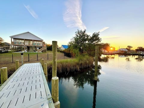 Private backyard dock with boat lift and fillet table, fenced-in backyard, fire pit with Adirondack chairs, hammocks, propane grill, picnic table, outdoor shower, expansive waterfront back deck, neighborhood boat ramp and dock