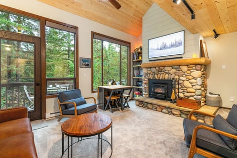 Living room with high ceilings, wood fireplace, and convenient motorized shades 