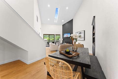 Bright, modern living space, high ceilings, natural light, stylish furnishings.