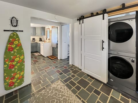 Stacked washer and dryer plus ironing board.