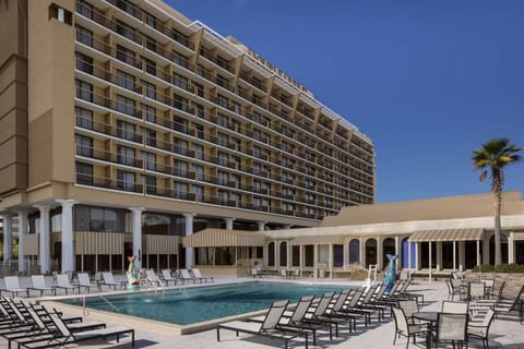 Pool area surrounded by tall building and sunny sky