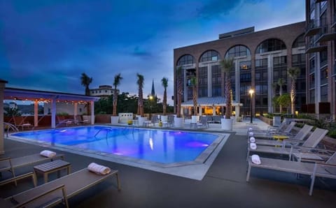 Outdoor pool with lounge chairs and palm trees