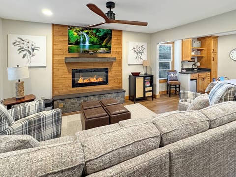 Cozy up by the fire for a movie night in this warm, wood-accented living room.