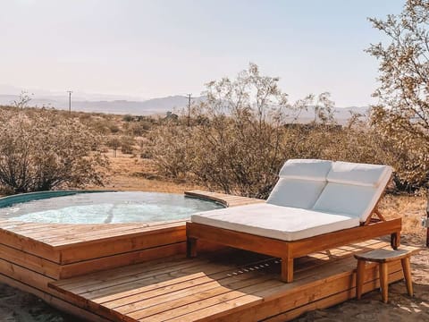 Large 10’ soaking pool surrounding by a sitting deck and lounge chairs - perfect for cooling off on summer days