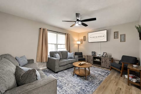 Bright, welcoming living room with large TV — great for watching sports, replays, and relaxing with your group.