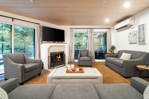 Cozy, sunken living room with comfortable seating, a gas fireplace, Smart TV, and air conditioning — a perfect spot to unwind year-round