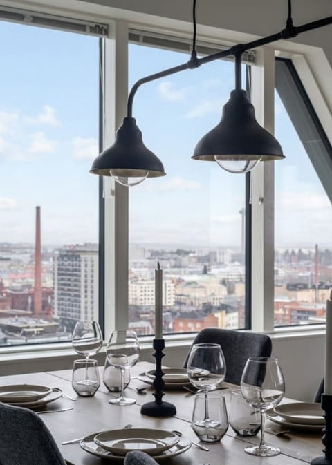 The kitchen opens up to a stylish dining area with seating for six, where you can enjoy your meals while admiring the stunning cityscape through large windows. It’s a wonderful spot for a relaxed breakfast or a cozy dinner with friends.