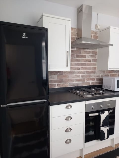 Modern kitchen with oven, hob, and black fridge freezer