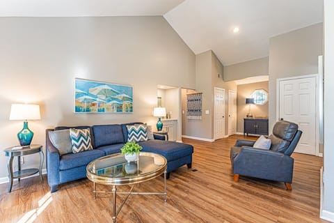Spacious living room with vaulted ceilings and modern blue seating.