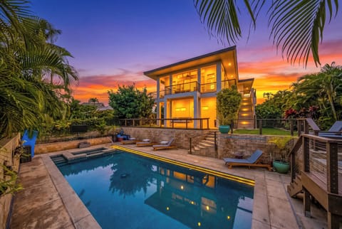 Kai Lani Ocean Villa at twilight, watch the outdoor TV while in the hot tub OR hang at the new Tiki Bar! Located only 4 Houses away from Shipwreck Beach!