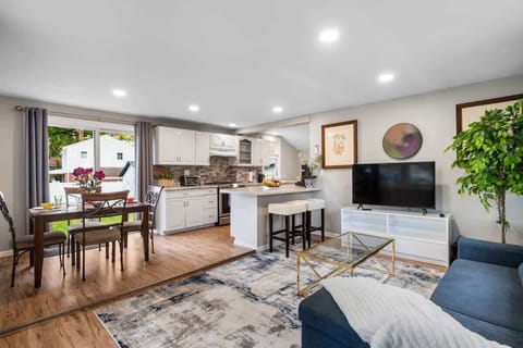 Step into a bright, open-concept home designed for comfort and connection. Large windows fill the room with natural light, while thoughtful touches—from the plush sofa to the fully equipped kitchen—make you feel right at home.