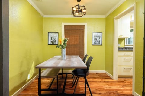 Cozy dining nook with a modern table, soft lighting, and warm green walls