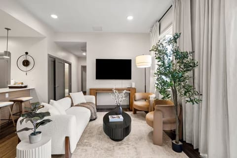 Bring and inviting living room with a cozy white sofa, stylish armchairs.