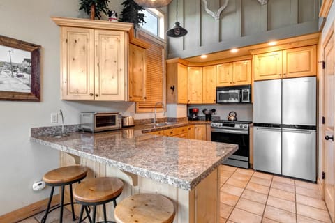 Cook with ease in your fully equipped kitchen featuring granite countertops, stainless appliances, and bar seating for casual bites. PEA-1260
