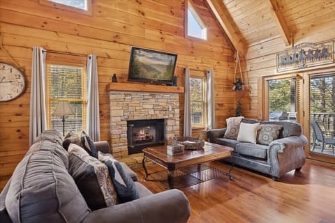Cozy living room with plush seating and a stone fireplace.