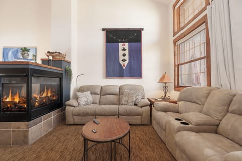Sink into plush recliners at Kicking Horse Palomino 7-302 by your cozy fireplace, where warm flames create the perfect ambiance for relaxation.
