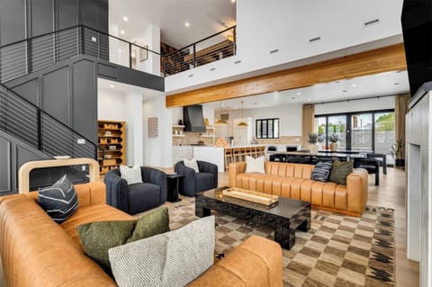 Main floor living room. Leather couches and swivel accent chairs. 2 story with large accent wall up the stairway